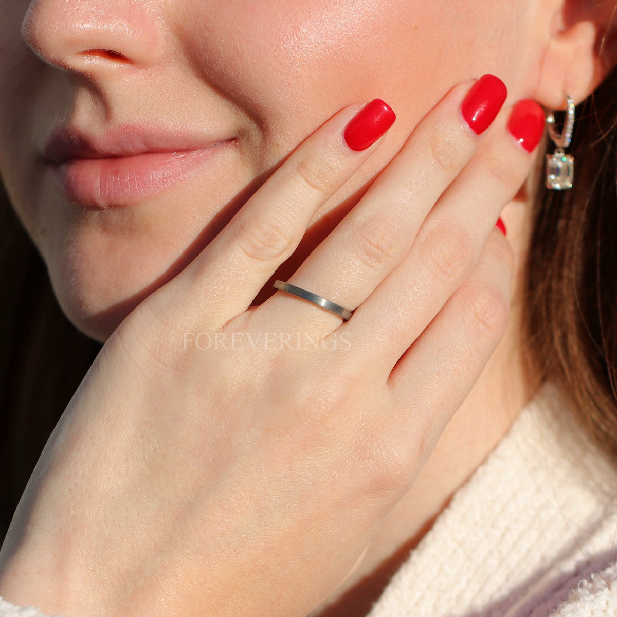 2mm brushed silver tungsten band worn on a woman's hand, wider view