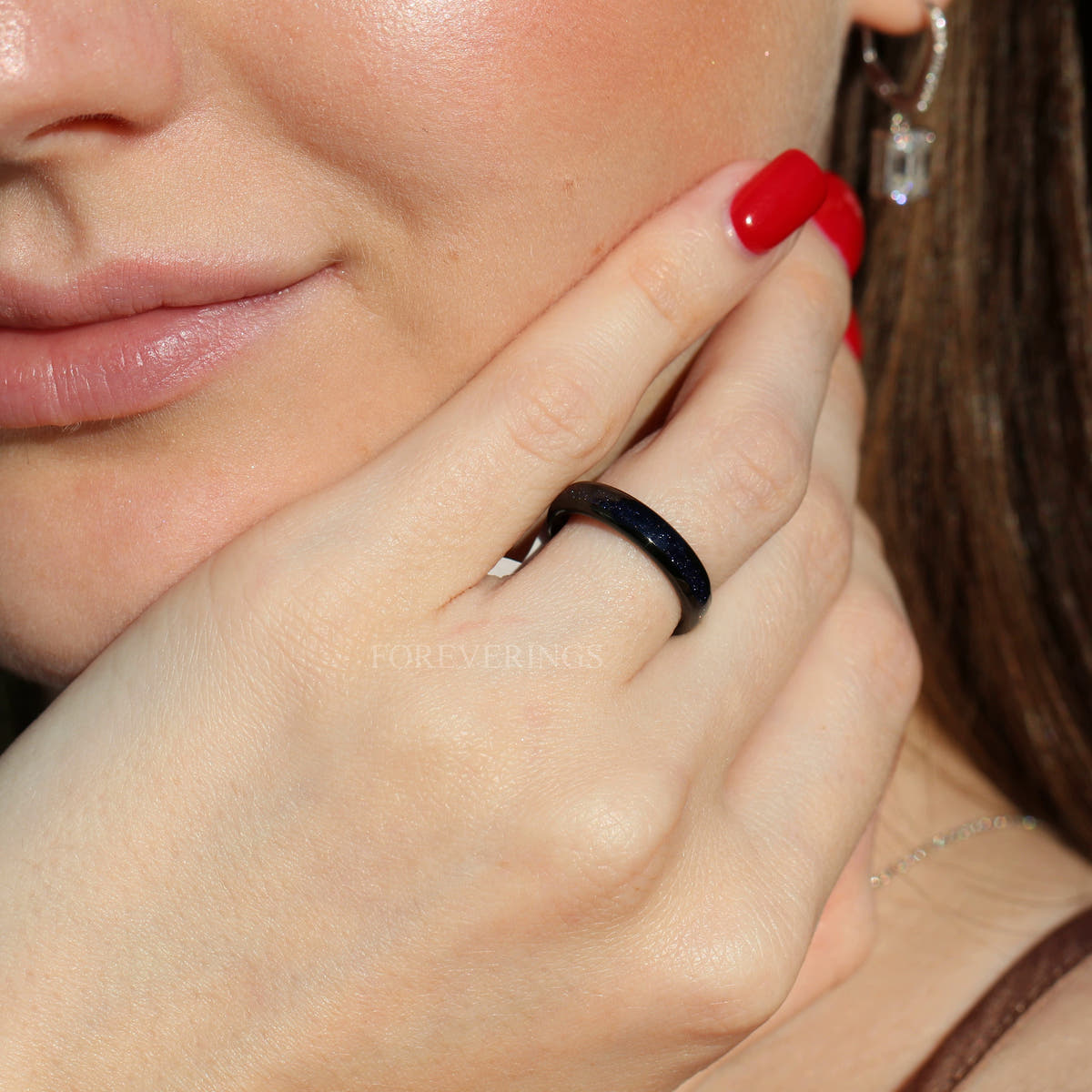 Women's 4mm black tungsten ring with blue sandstone inlay, worn on a hand
