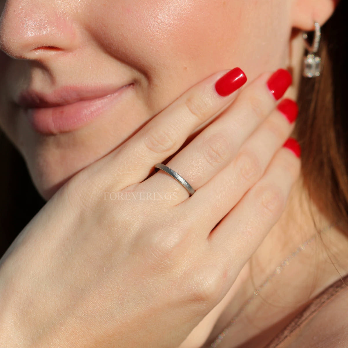 Thin 2mm sandblasted silver tungsten band worn on a woman's hand