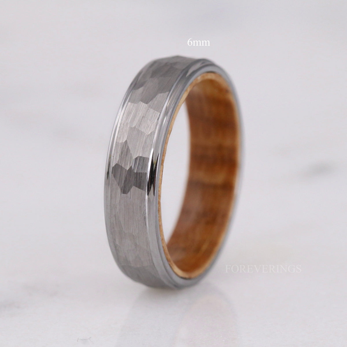 6mm hammered silver tungsten band with whiskey barrel wood interior, standing upright