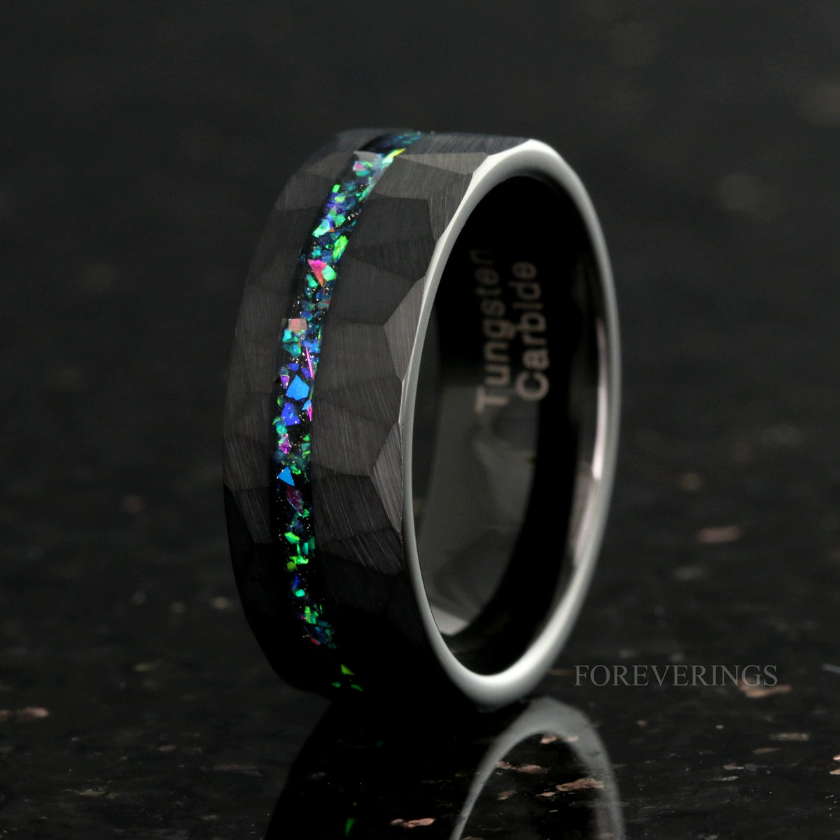 Men's 8mm hammered black tungsten ring with galaxy opal inlay, standing at an angle