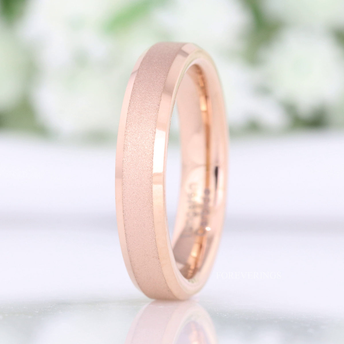 4mm sandblasted rose gold tungsten wedding band standing at an angle, beveled edges