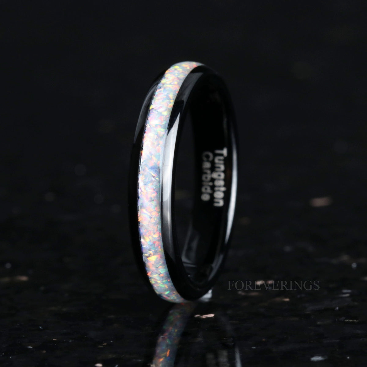 Women's 4mm black tungsten ring with white fire opal inlay, standing on edge