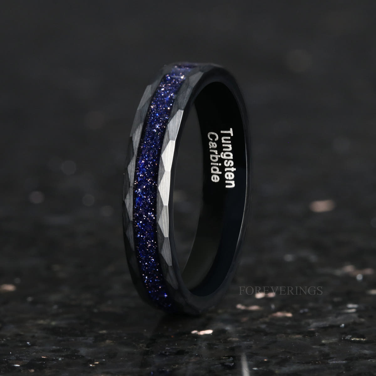 Hammered black tungsten Great Rift nebula ring standing on edge, wider view