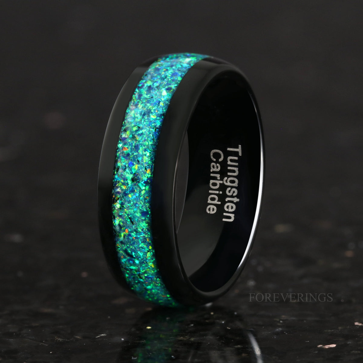 Men's 8mm black tungsten ring with emerald opal inlay, angled to show the interior