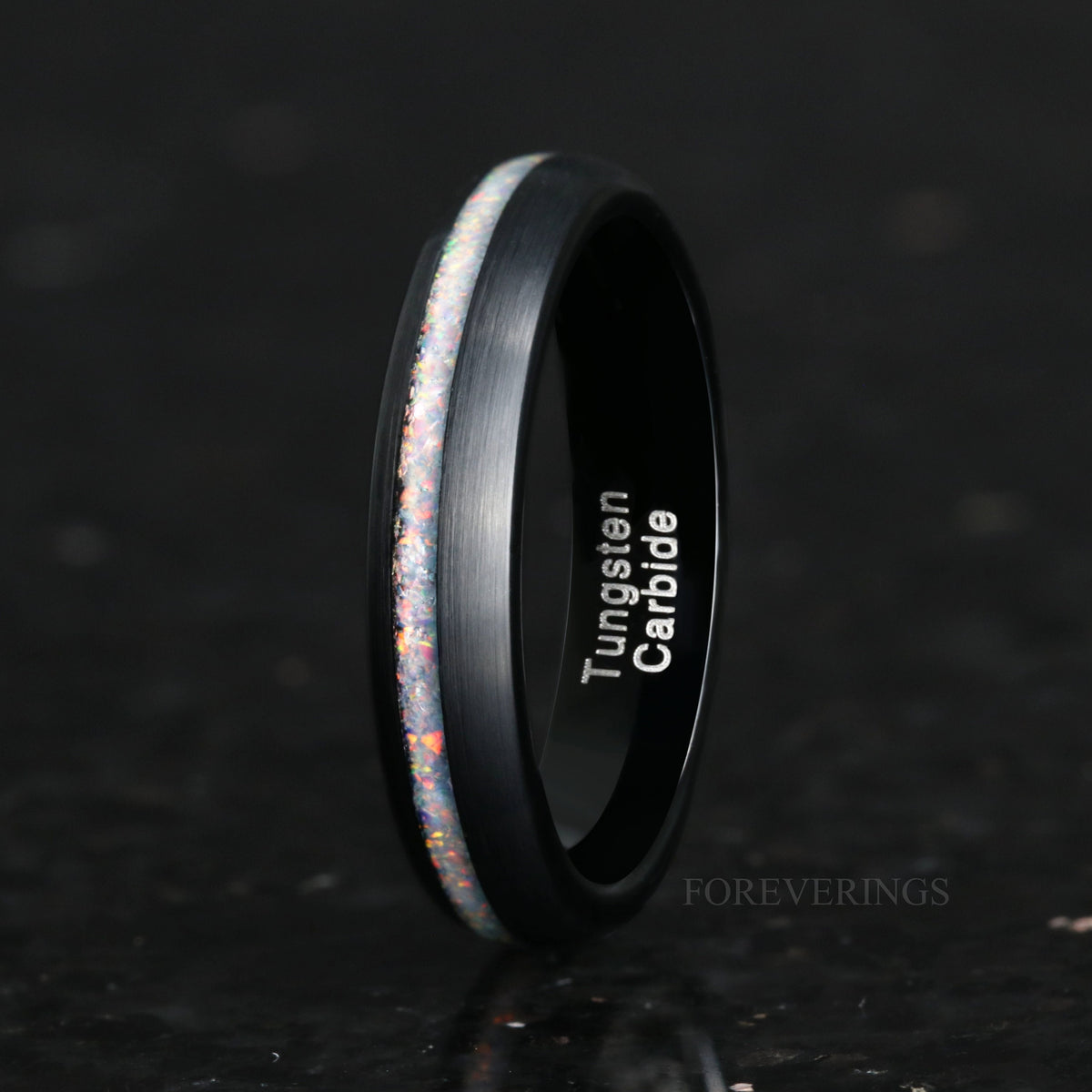 Women's 4mm black tungsten ring with white fire opal inlay, standing upright