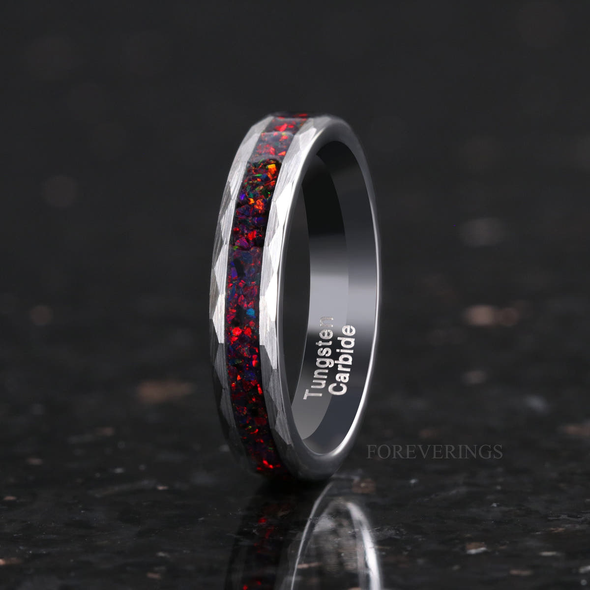 Women's 4mm hammered silver tungsten ring with black fire opal inlay, standing at an angle