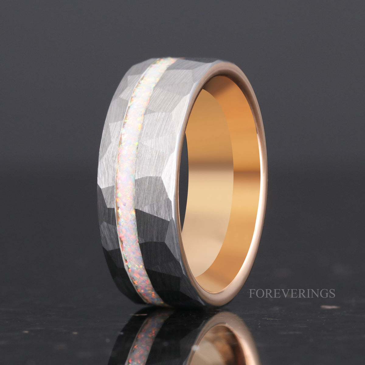 Men's 8mm hammered tungsten ring with white fire opal, angled to show the rose gold interior