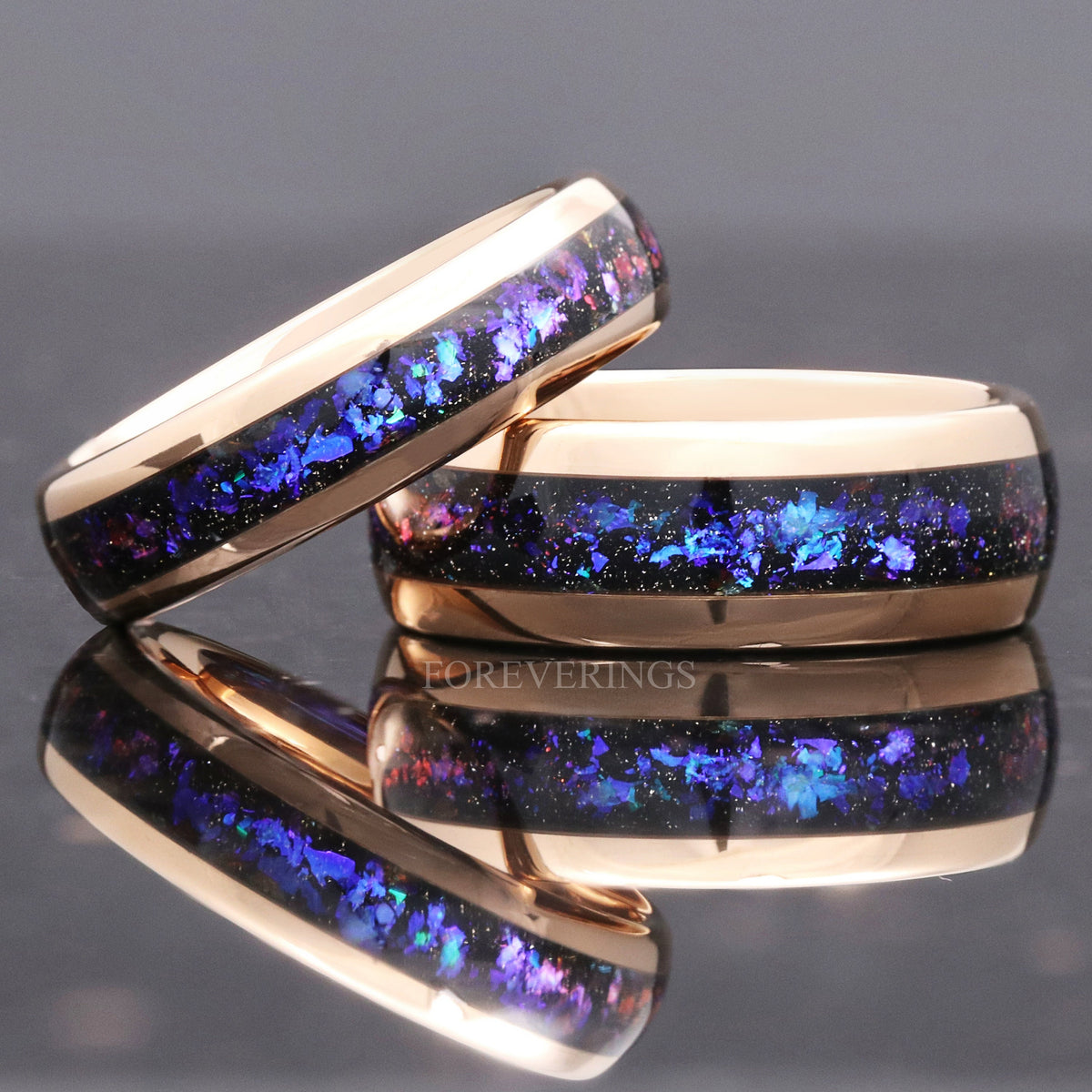 Wide and narrow rose gold tungsten bands with nebula sandstone inlay leaning together