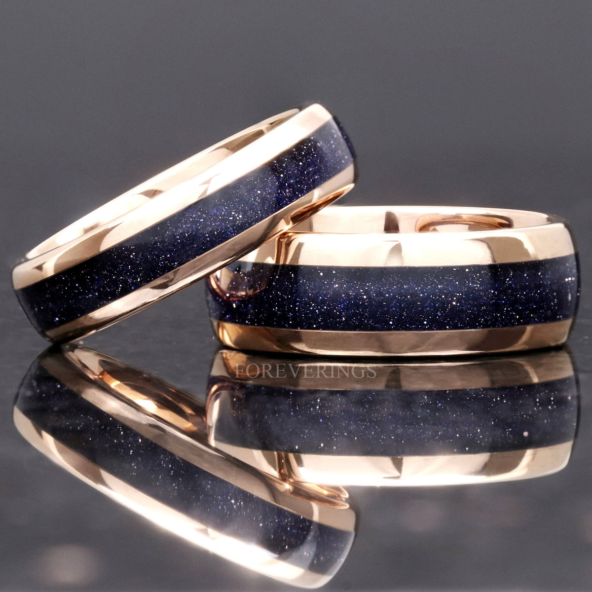 Two widths of the rose gold tungsten band with blue sandstone inlay, narrow ring leaning on a wide one