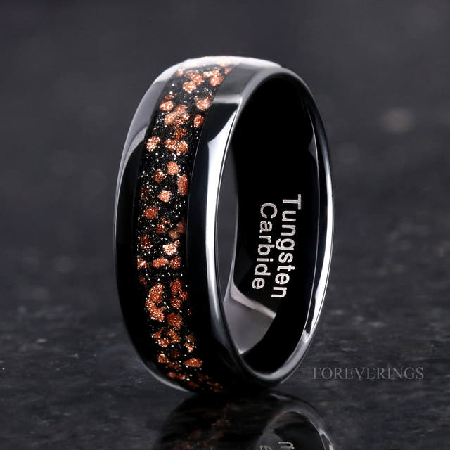 His 8mm black tungsten ring with red goldstone inlay, angled to show the interior