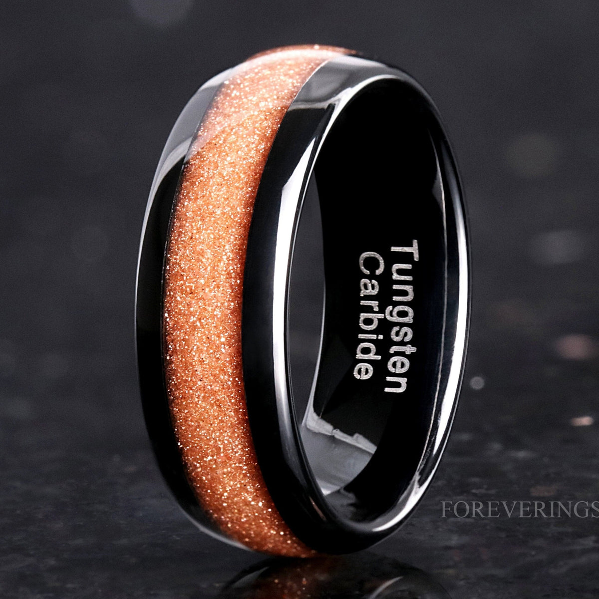 Men's 8mm black tungsten band with Carina nebula red sandstone inlay, angled to show the interior