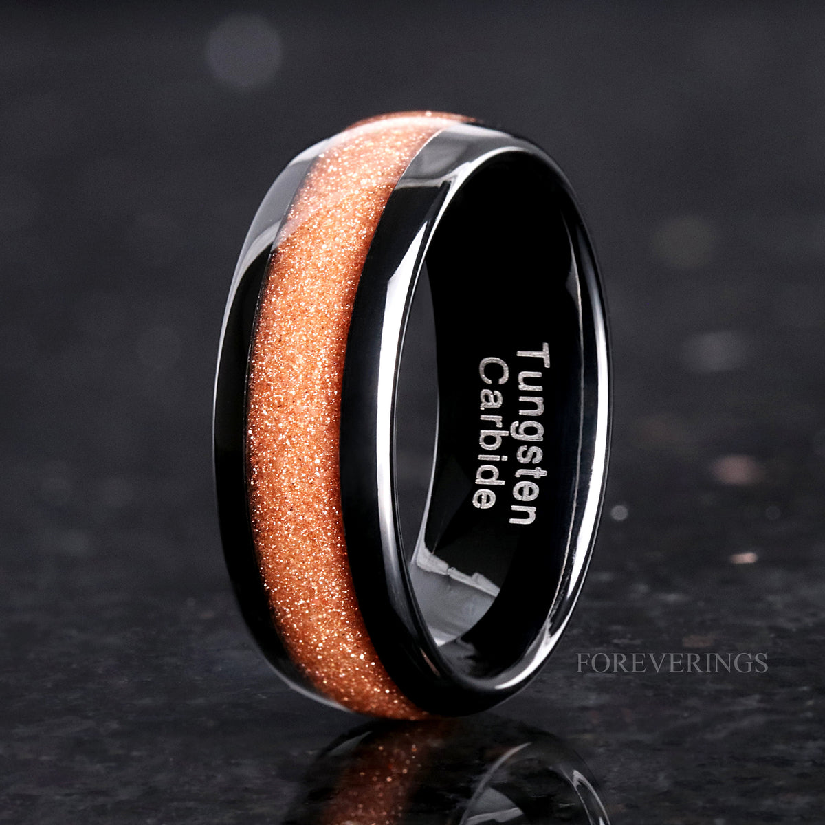 Men's 8mm black tungsten band with a crushed red sandstone stripe, standing to show the interior