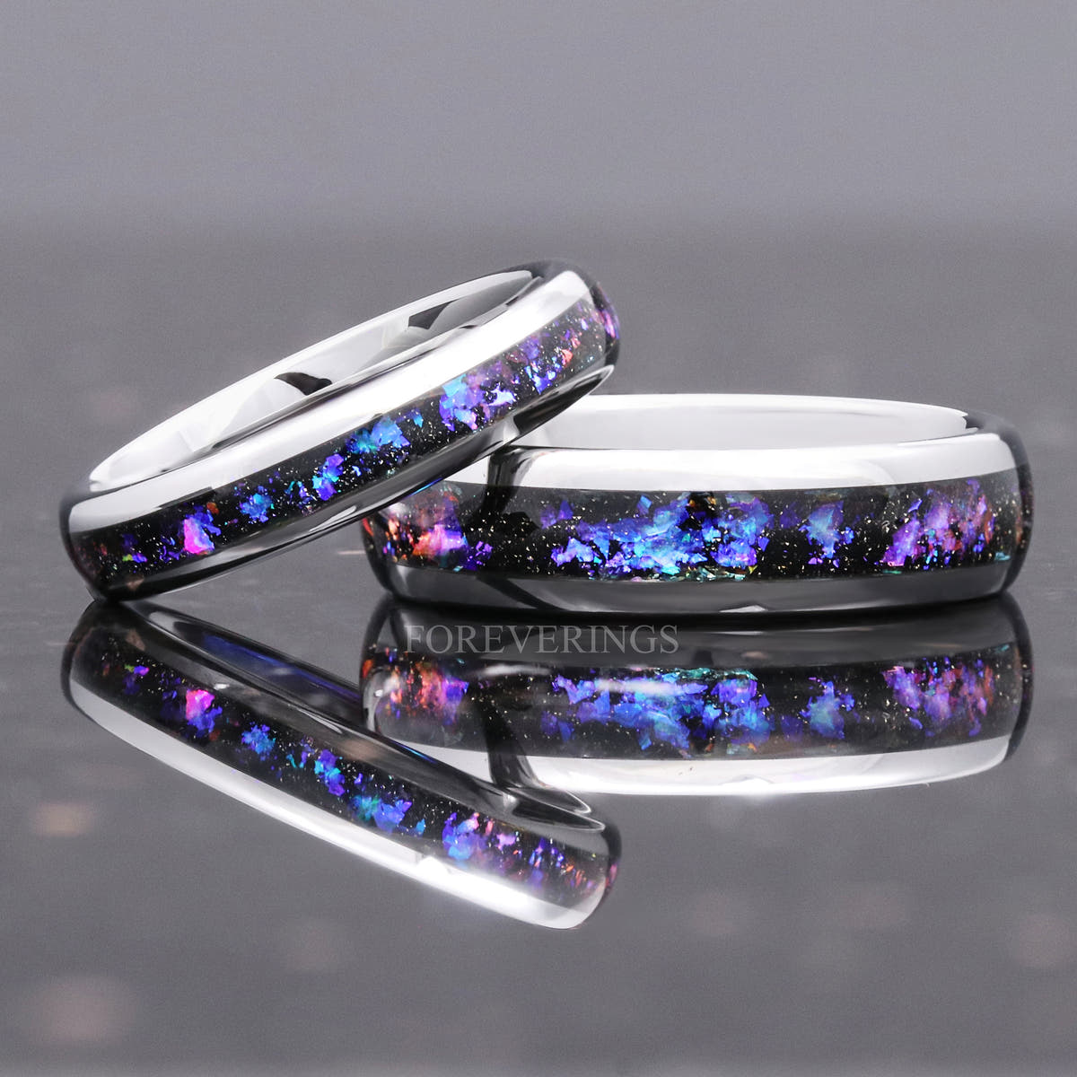 Slim silver tungsten nebula band propped against a wider band, alternate angle
