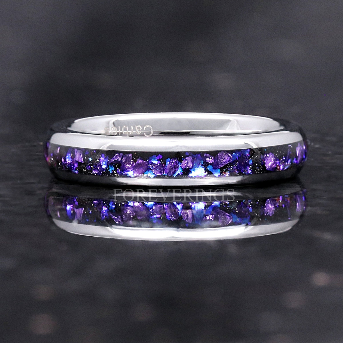 Silver tungsten wedding band with purple alexandrite inlay lying flat, front view with reflection