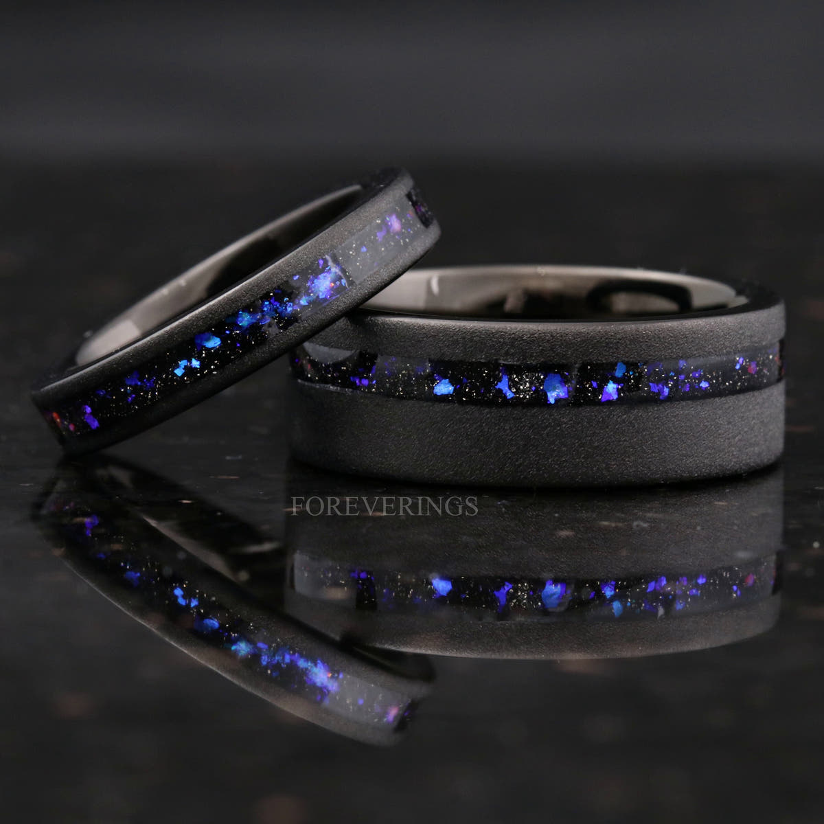 Thinner nebula inlay band resting on the black sandblasted tungsten ring, close crop