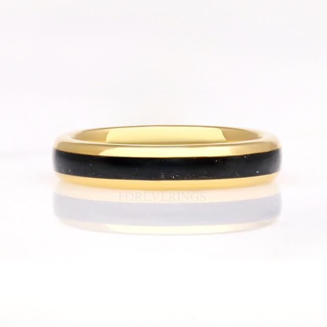 Gold tungsten black onyx ring lying flat, front view with reflection