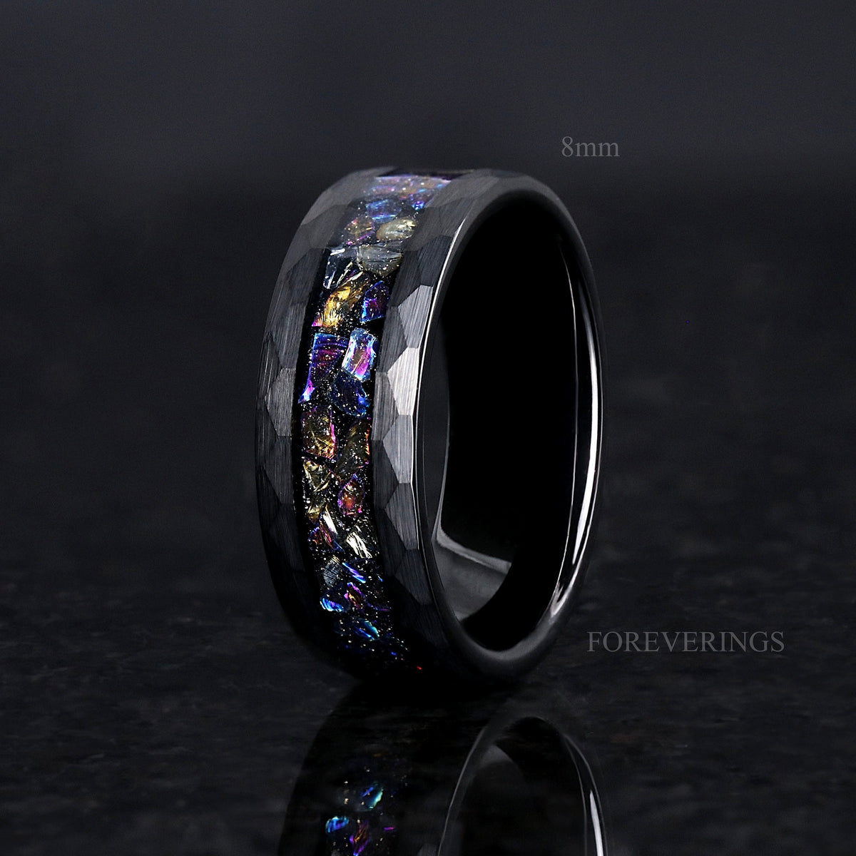 Men's 8mm black hammered tungsten band with moonstone inlay, standing at an angle