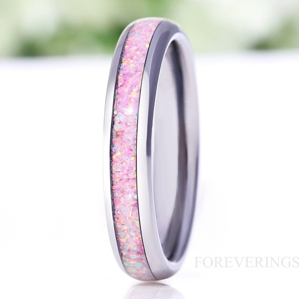 Women's 4mm silver tungsten ring with pink unicorn fire opal inlay, angled close-up