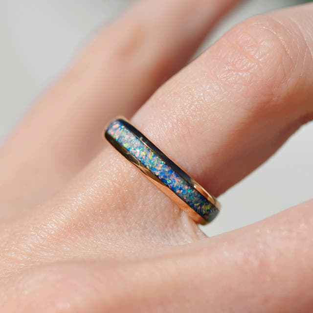 4mm rose gold tungsten rainbow fire opal ring worn on a finger