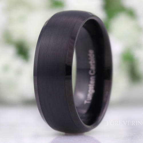 Men's 8mm matte black tungsten wedding band with beveled edges, standing at an angle