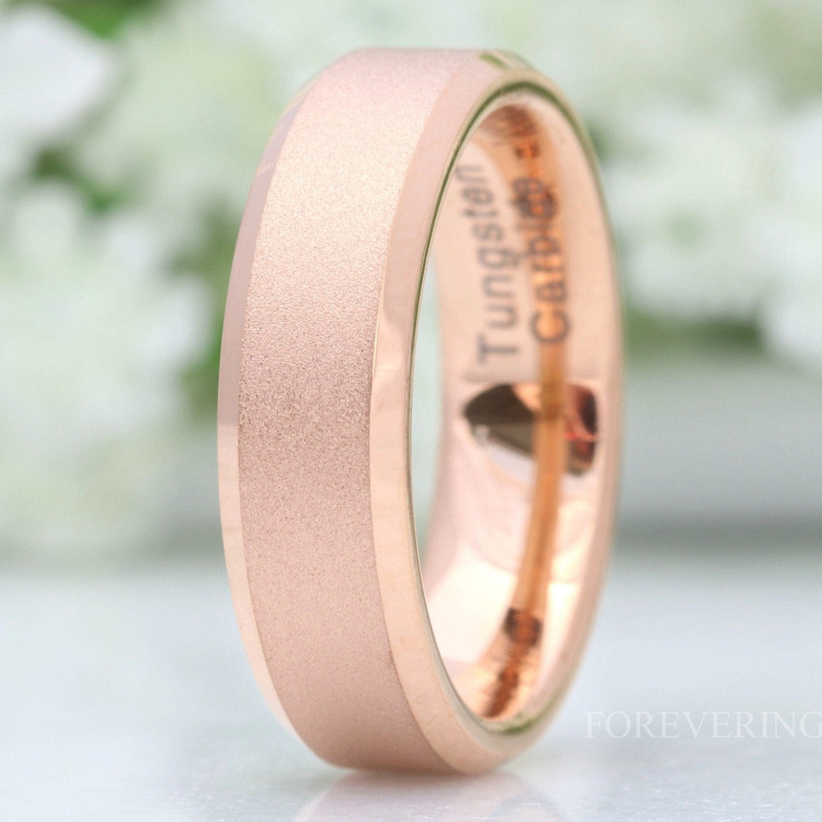 6mm sandblasted rose gold tungsten band with polished beveled edges, standing in a close crop