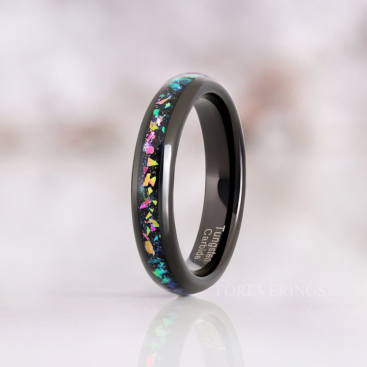 Her 4mm black tungsten ring with multicolor supernova inlay standing on edge