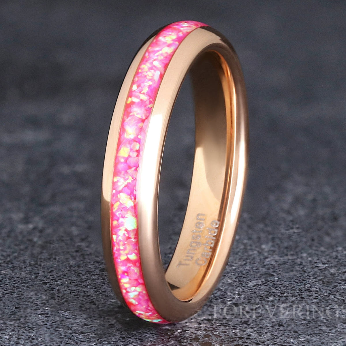 Women's 4mm rose gold tungsten band with pink fire opal inlay, standing at an angle