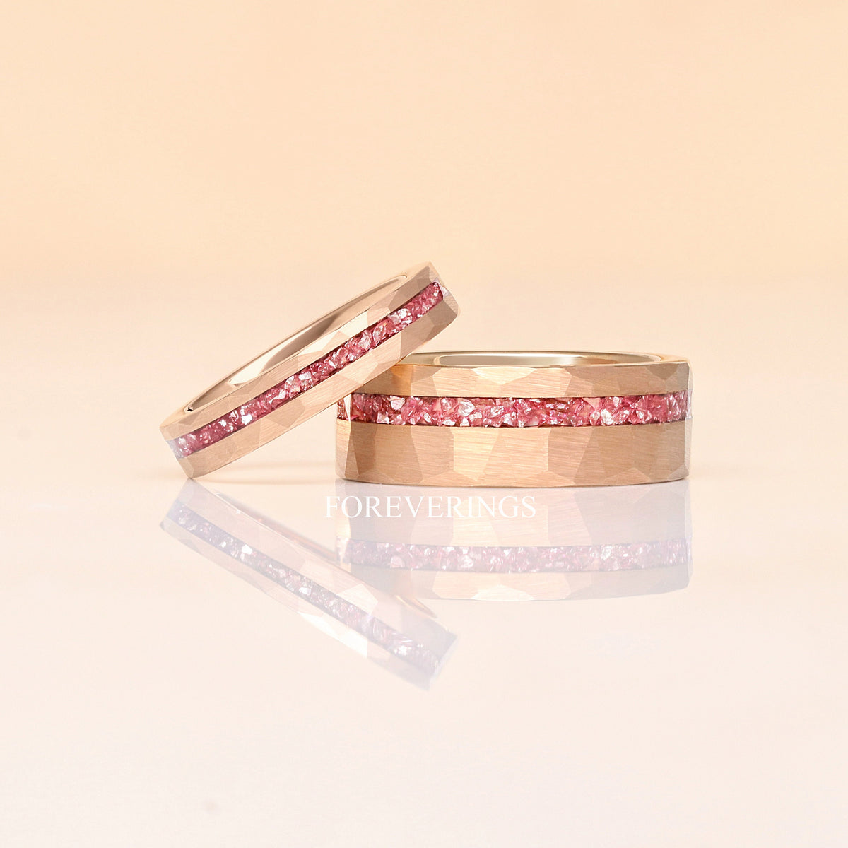 4mm hammered rose gold tungsten morganite band leaning on a wider hammered rose gold morganite band