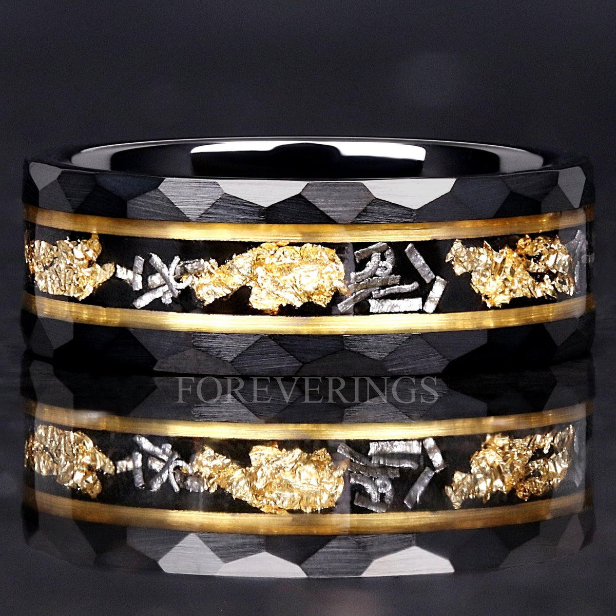 Hammered black and gold tungsten wedding band lying flat, meteorite and gold leaf facing forward