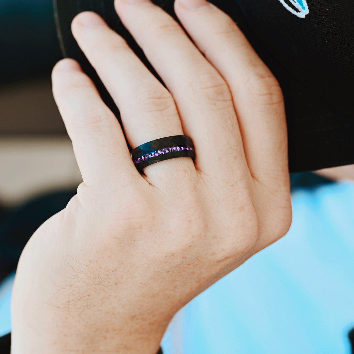 Men's 8mm black Damascus steel alexandrite ring worn on a hand
