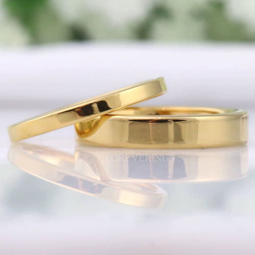 Men's and women's minimalist flat gold tungsten wedding bands in 2mm and 4mm, lying together