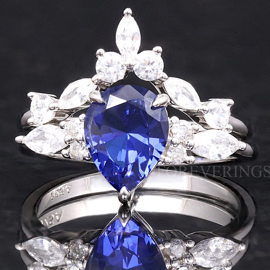 Women's sterling silver bridal set with a pear-cut sapphire and a curved marquise accent band, front view