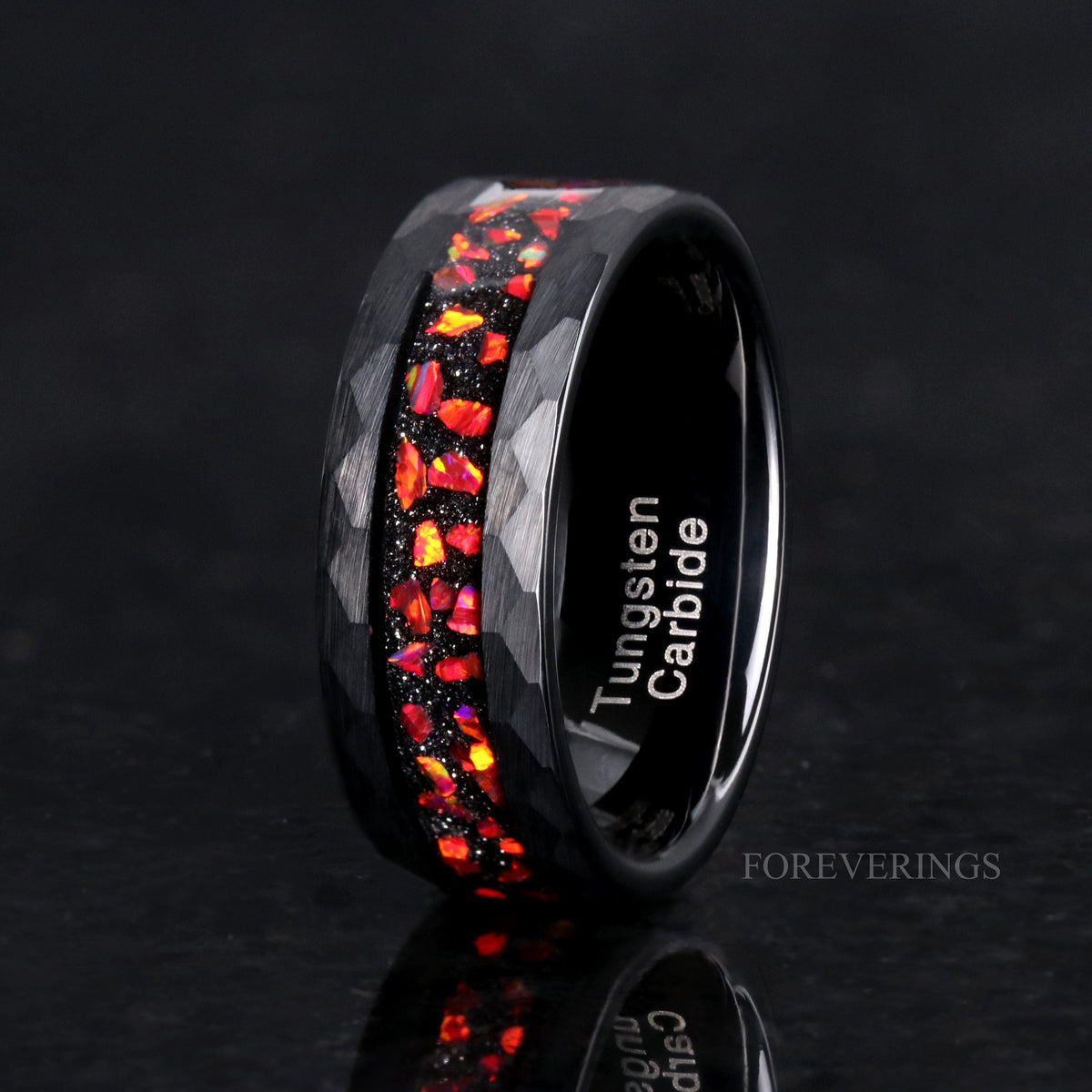 Men's 8mm hammered black tungsten ring with crushed red fire opal inlay, standing at an angle