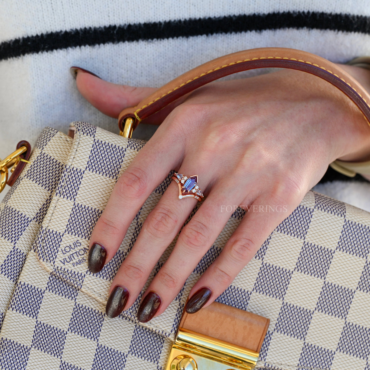 Rose gold alexandrite engagement ring set worn on a hand
