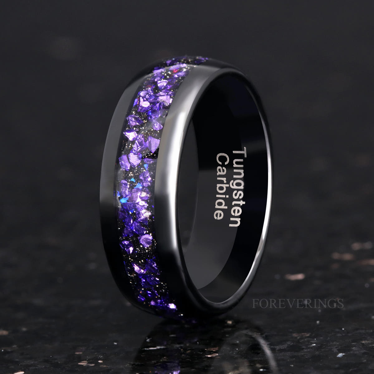 Men's 8mm black tungsten band with alexandrite and purple sandstone inlay, standing on edge