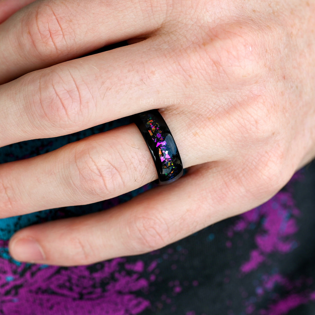 Men's 8mm black tungsten band with multicolor supernova inlay worn on a hand