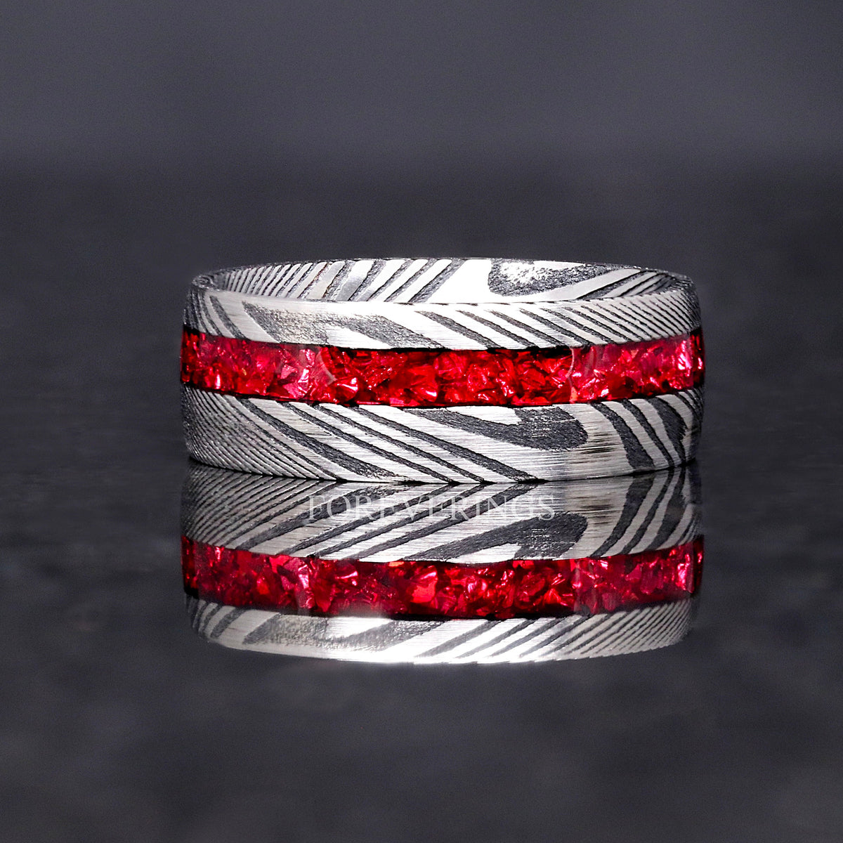 Damascus steel band with a garnet stripe shown straight on, reflection below