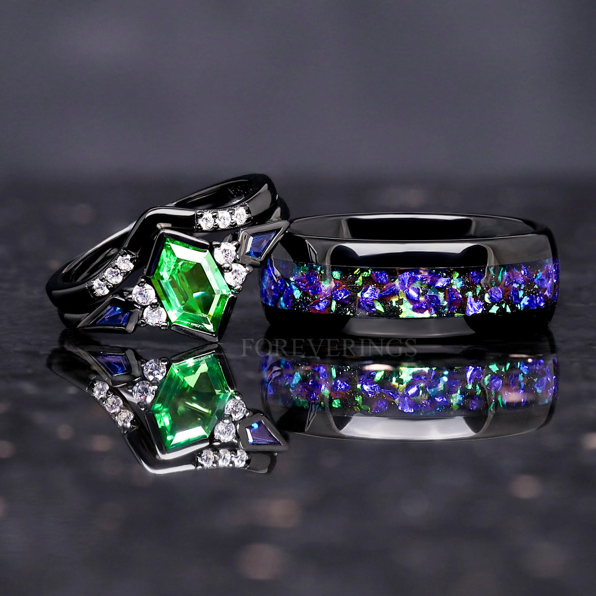 His and hers wedding ring set in black tungsten and sterling silver with green tsavorite, angled view