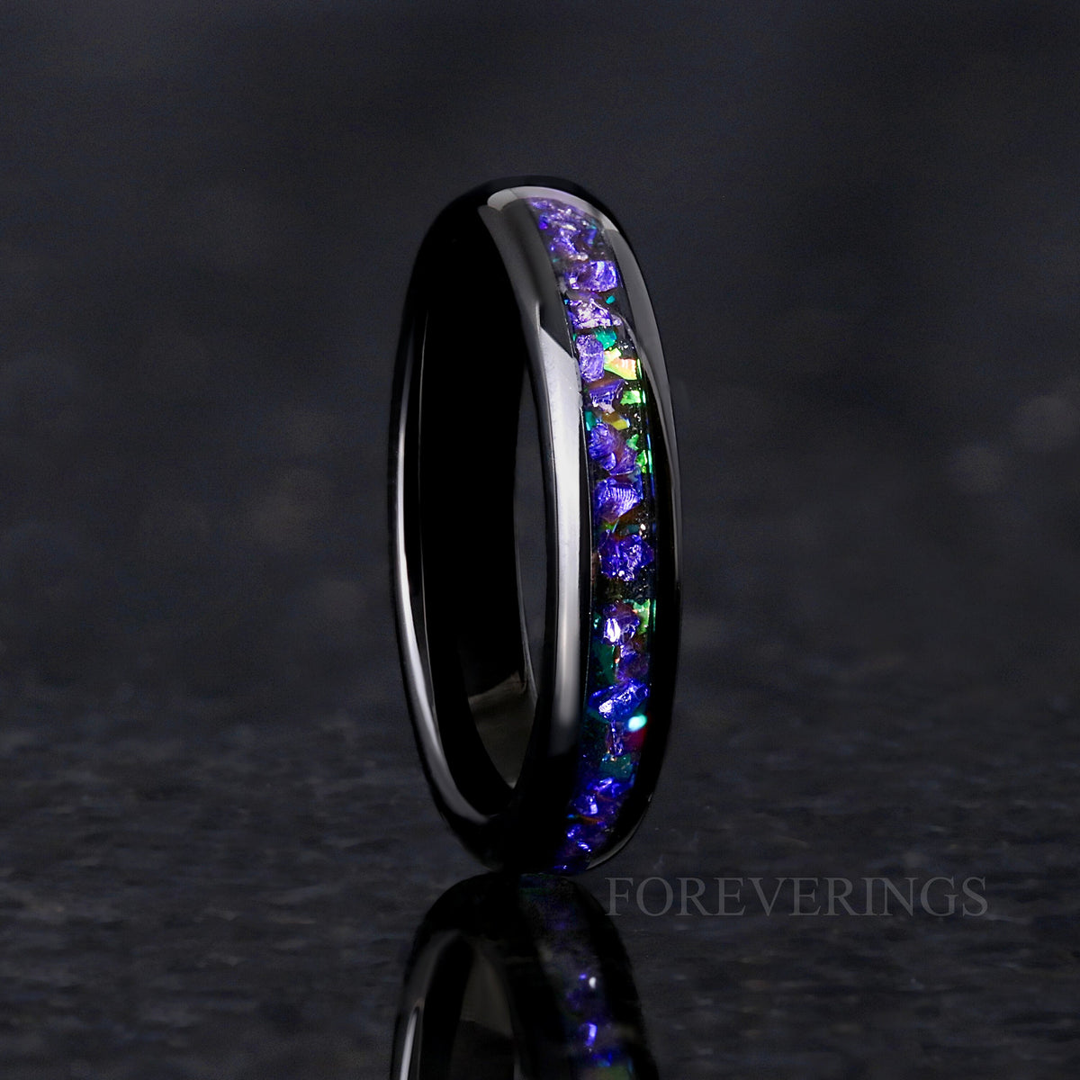 Women's 4mm black tungsten ring with purple and blue nebula inlay, standing on edge