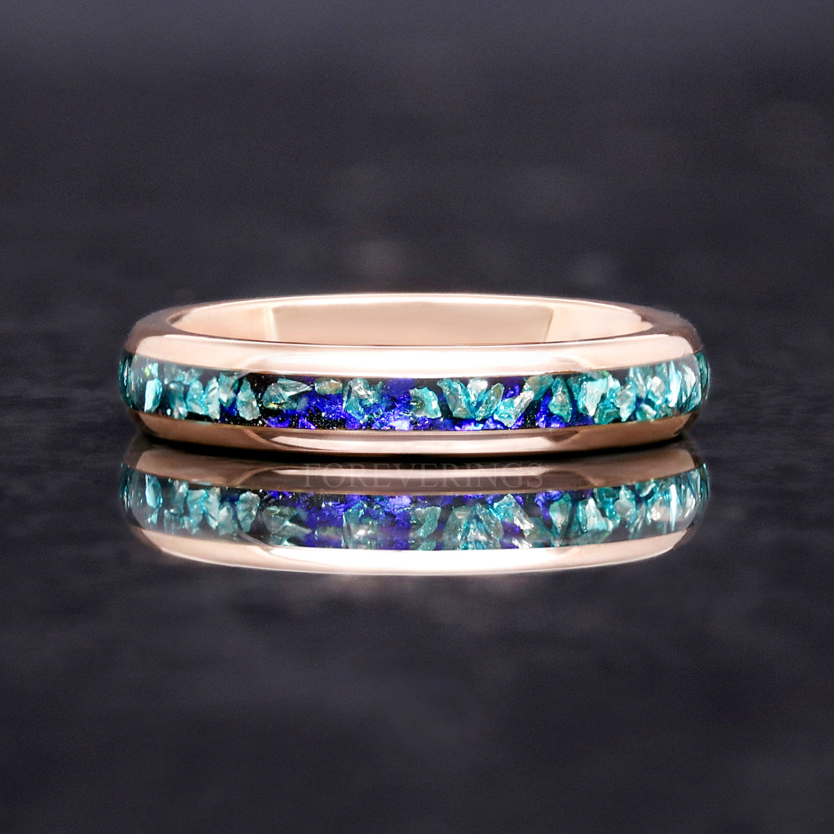 Rose gold tungsten band with crushed aquamarine inlay shown straight on, reflection below