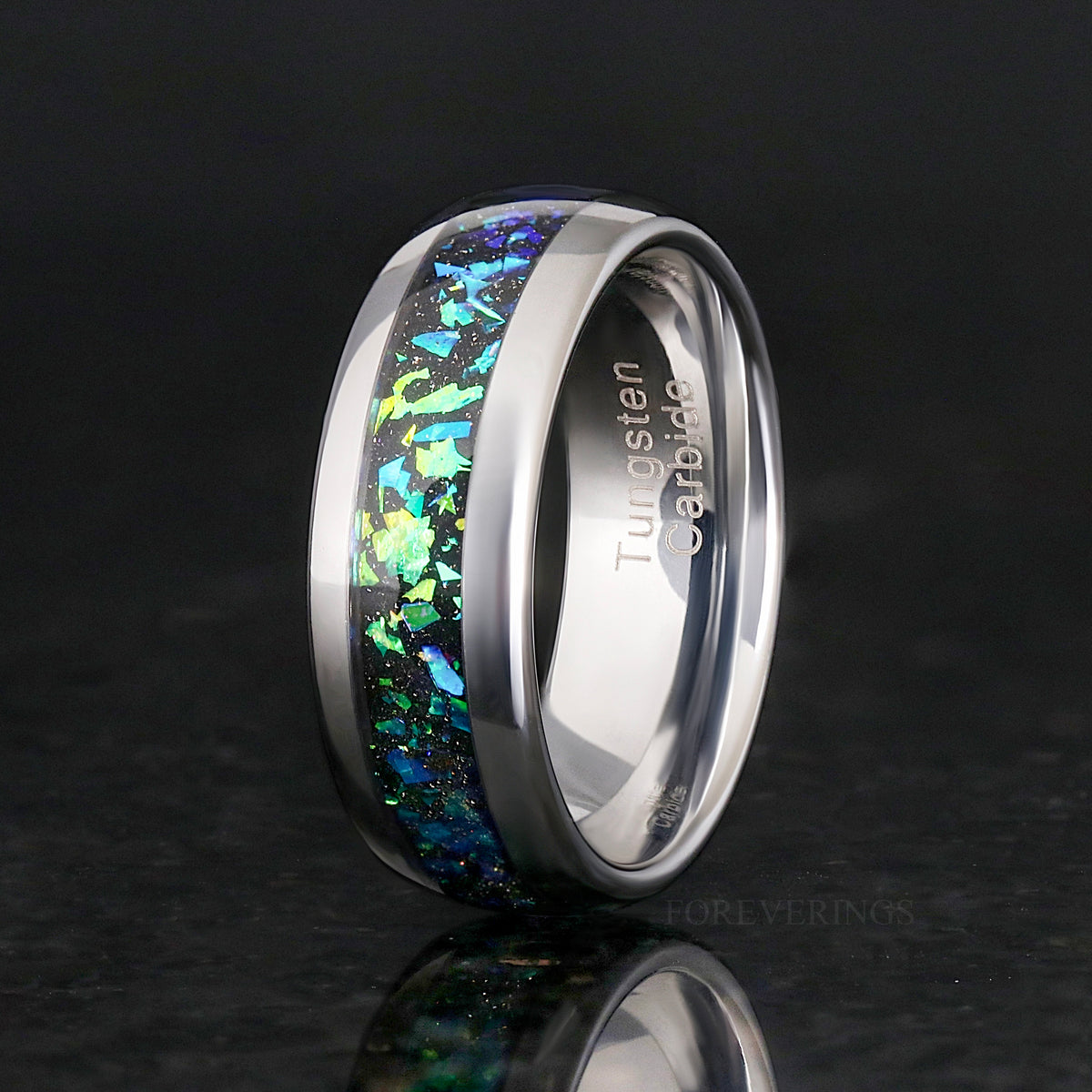 Men's silver tungsten band with green nebula inlay standing upright at an angle