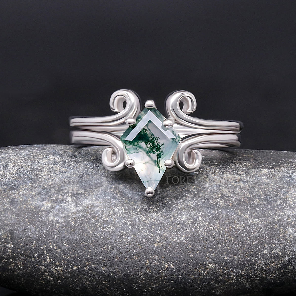 Sterling silver moss agate engagement ring with swirl details and a curved band, straight on