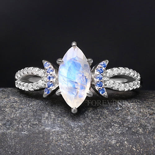Women's sterling silver marquise moonstone ring with blue sapphire crescent accents, close crop