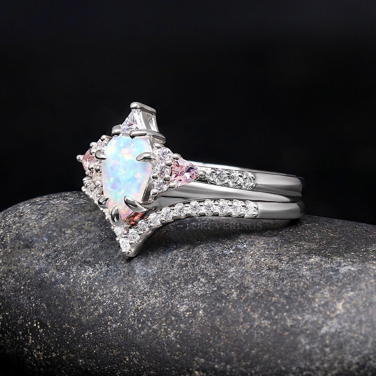 Women's sterling silver white opal engagement ring with curved pave band, angled side view