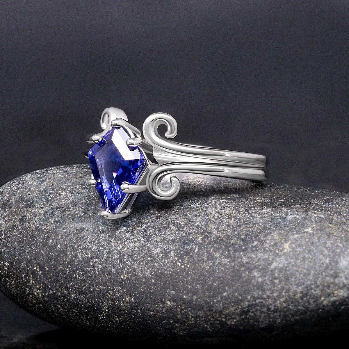 Sterling silver kite-cut sapphire engagement ring with swirl shoulders, angled side view