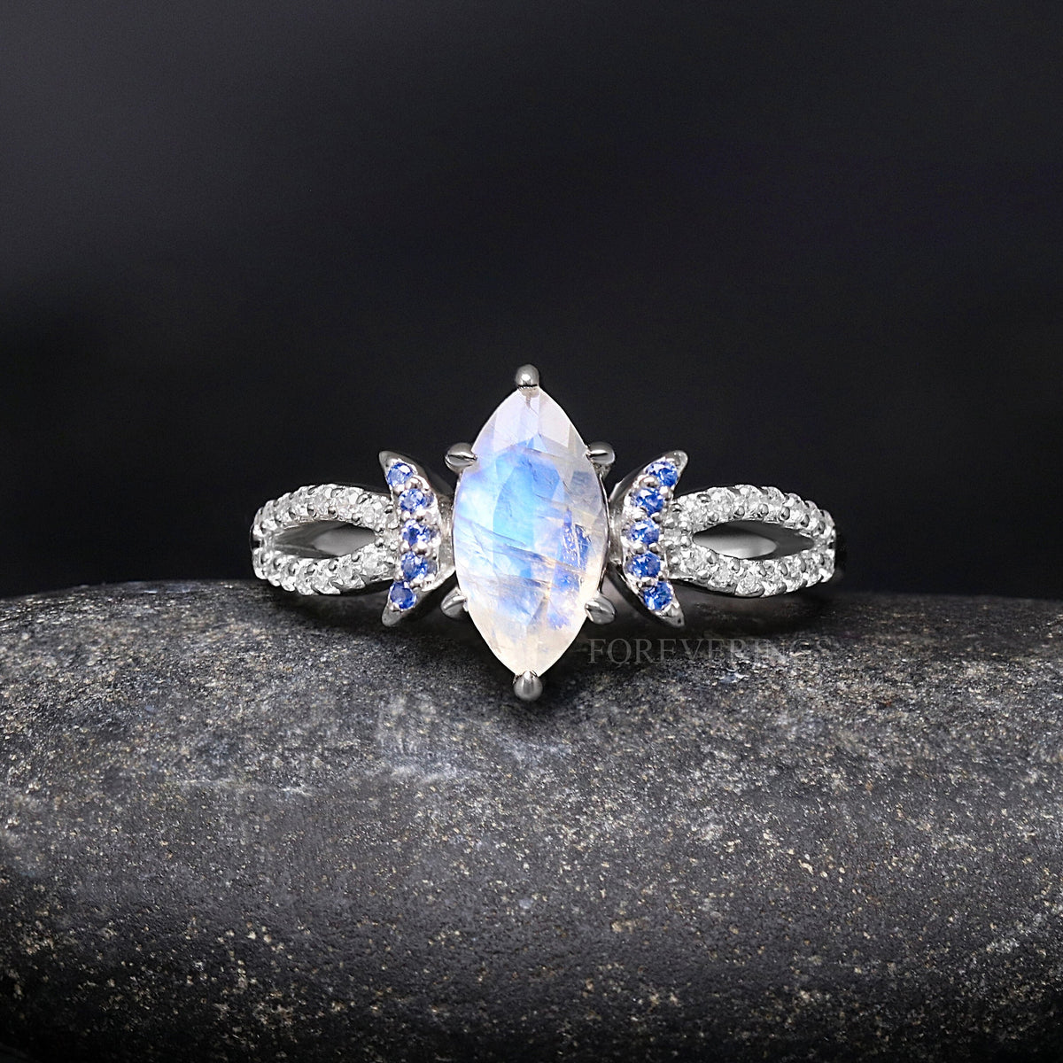 Marquise moonstone ring shown straight on, split band set with white stones