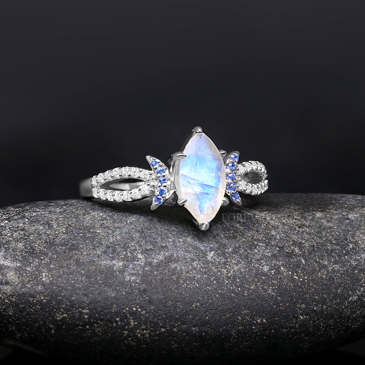 Women's sterling silver marquise moonstone ring with crescent moon blue accents, slightly angled