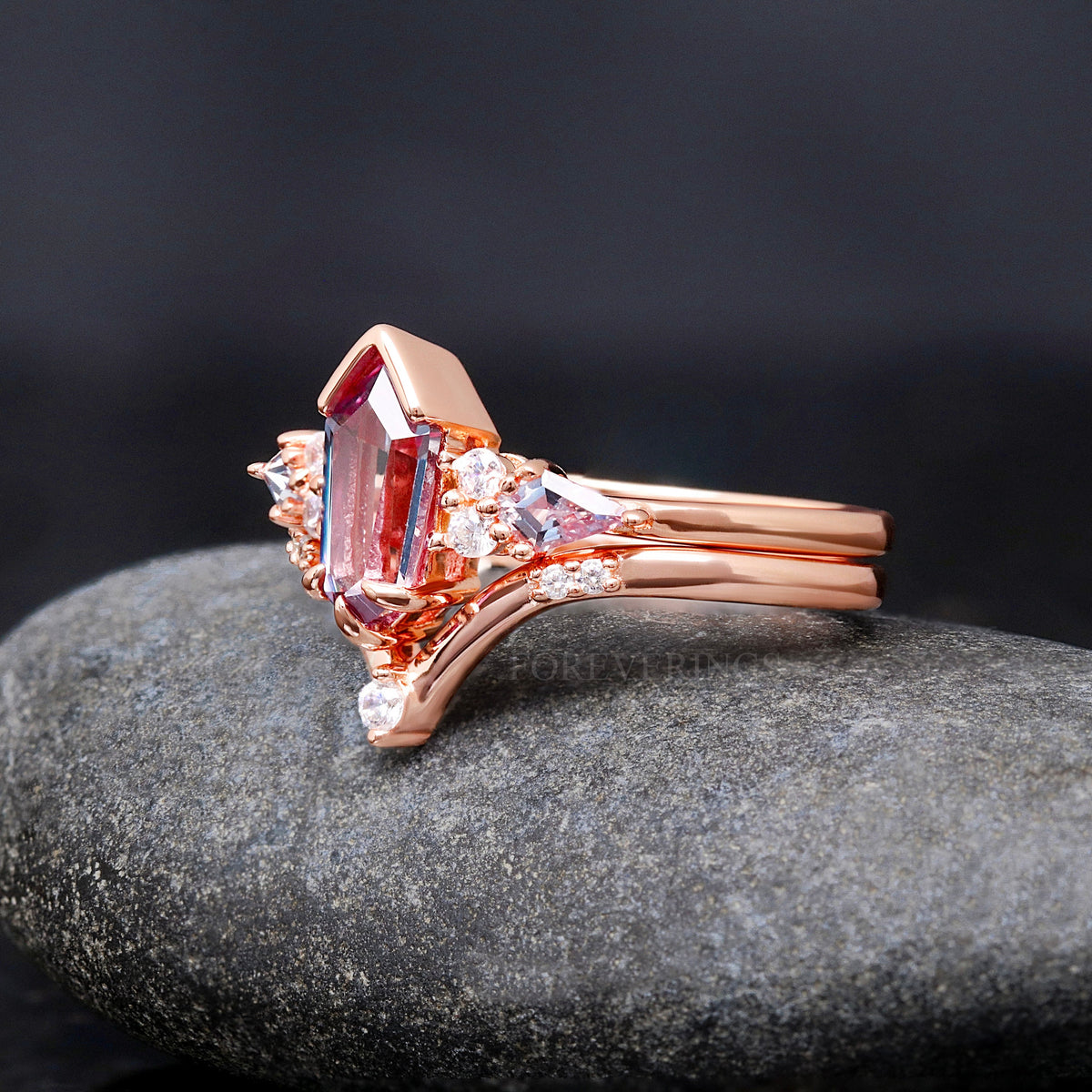 Angled side view of her rose gold alexandrite engagement ring nested with a curved band