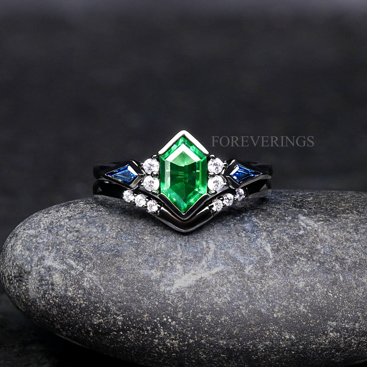 Women's black sterling silver engagement ring set with a hexagon tsavorite and blue side stones, front view